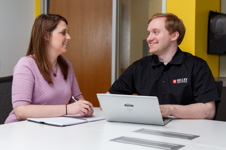 An advisor and student discuss in an office.