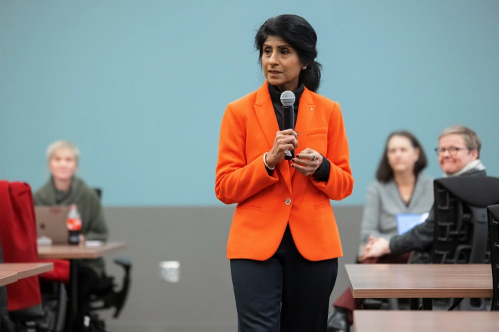 The chancellor speaks in front of a room of people