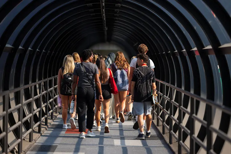 Students walking through tube passageway