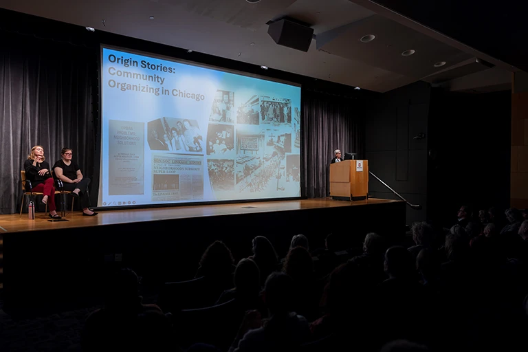 Presentation on projector screen reading Origin Stories: Community Organizing in Chicago
