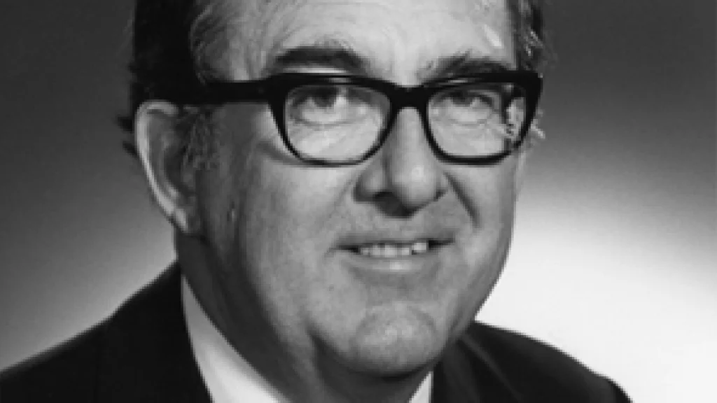 Chancellor Glenn Irwin in a suit, wearing glasses, in a portrait against a blank backdrop.
