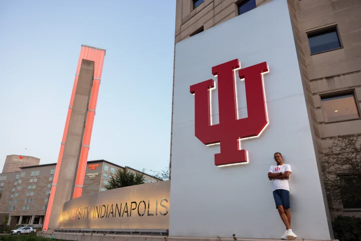 Proud IU alum standing near a large IU trident
