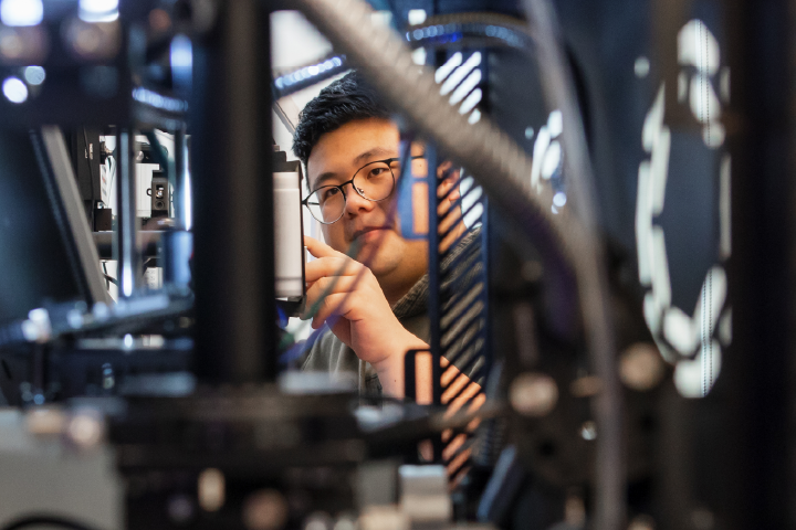 Multiple people in suit jackets and collared shirts sit at a conference table discussing a serious issue.