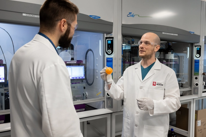 Two students talk in a laboratory.