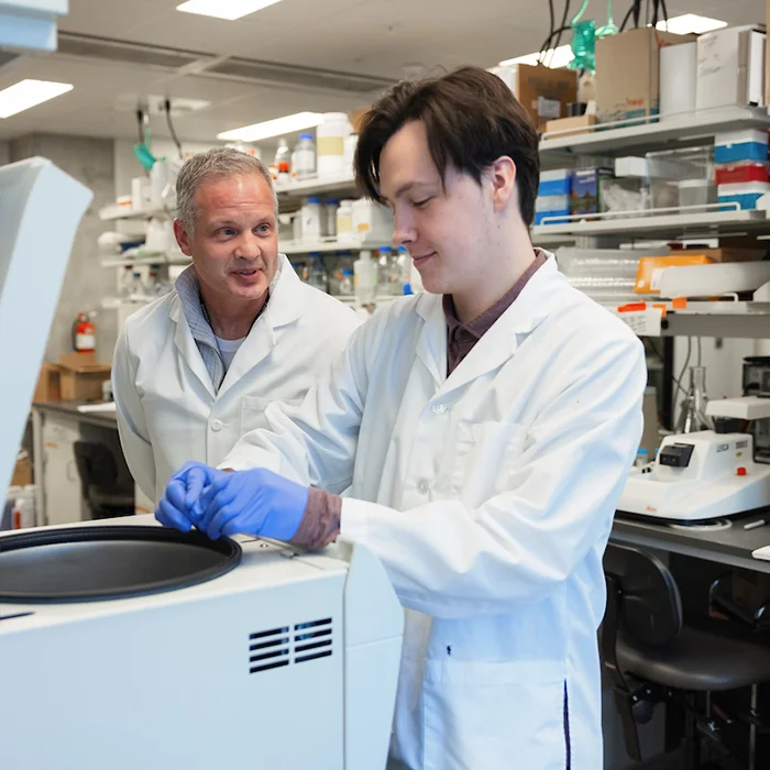 Two people using centrifuge