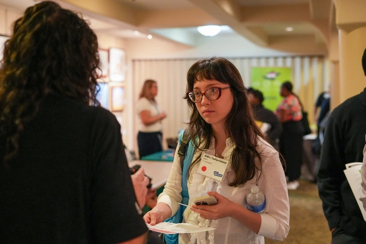 A young person talks to another person at an Indy Achieves event.