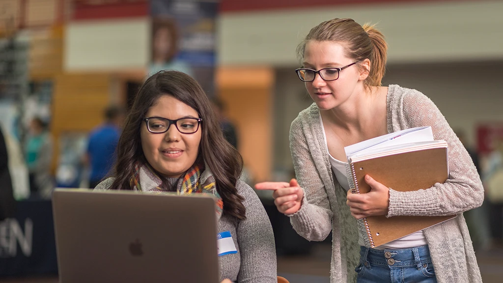Two people looking at a laptop together