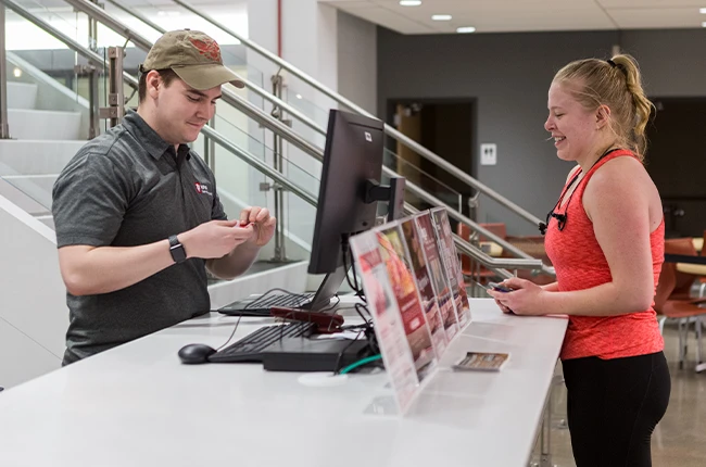 Two people standing on either side of a reception desk