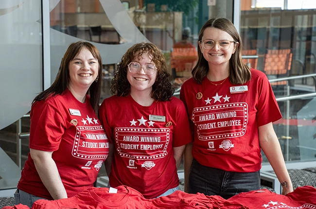 Three people wearing shirts that say Award Winning Student Employee