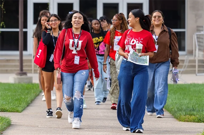 A group of students in IU gear walk across campus